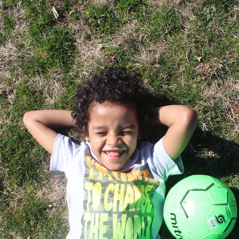 Child Smiling with Soccer ball